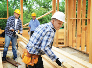 construction workers on a background of a frame house