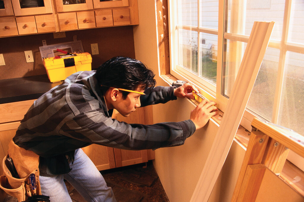 Builder remodeling a kitchen window.