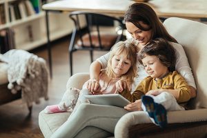 Photo of young mother and children sitting with tablet