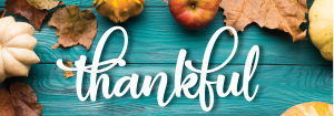 thankful on teal wood background and autumn leaves