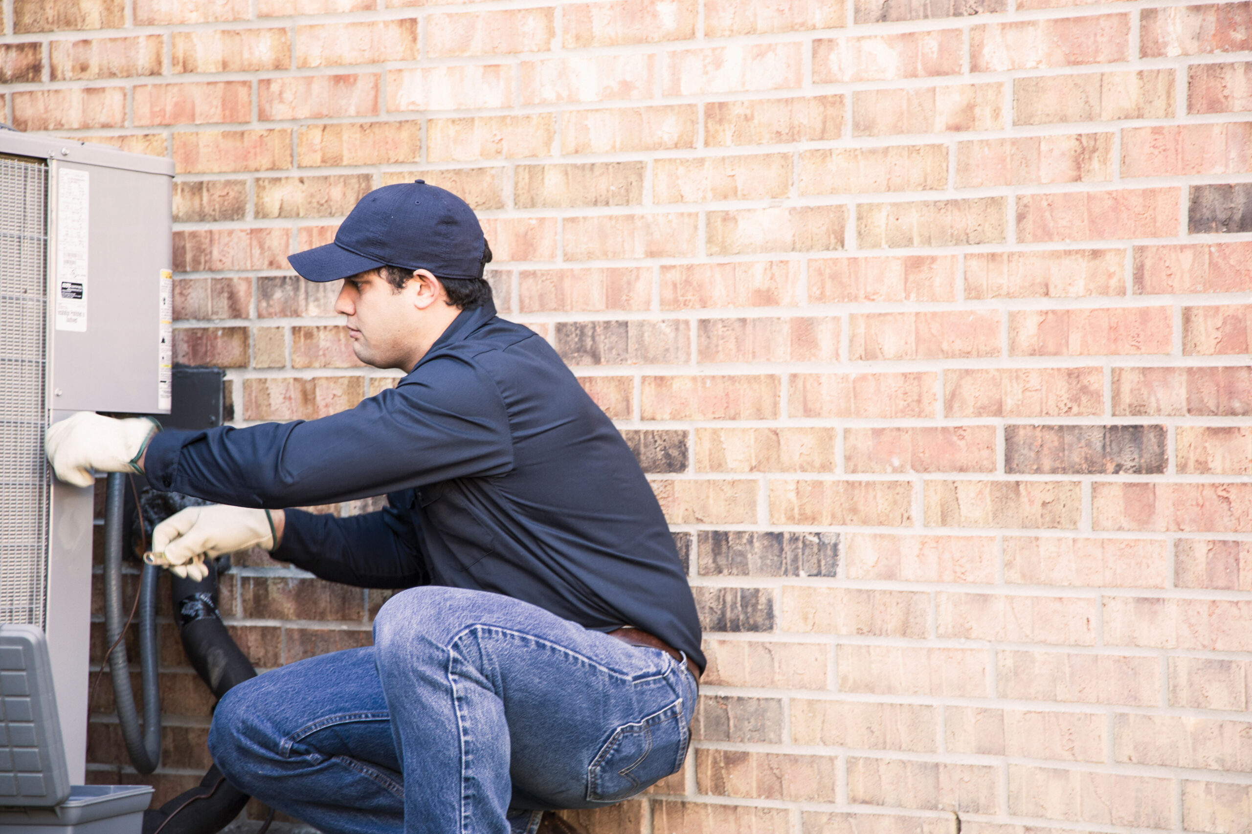 repair man working on air conditioner unit