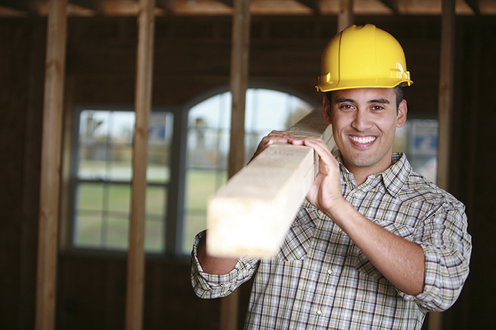 builder carrying wood on job site new home construction protected by new home warranty coverage